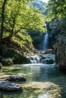 Waterfall flows in nature. Stream runs under trees. Mountain water cascade. Rocks sit in clear pond. photo