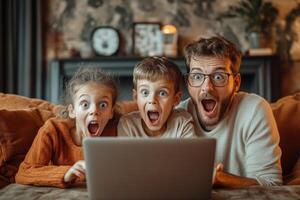 Father and two children look at a laptop computer with surprised expressions. They sit together on a sofa in a cozy home interior. photo