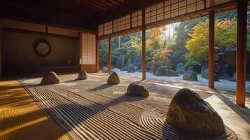Zen garden inside building with raked sand and stones looking out to colorful trees. Peaceful scene with calming atmosphere and natural light streaming in. photo