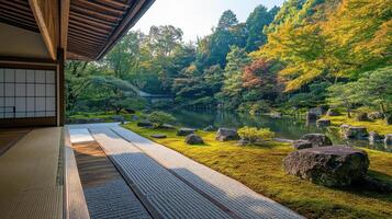Japanese garden view from building with tatami mats. Gravel path leading to pond with mossy rocks and trees in colorful autumn foliage. photo