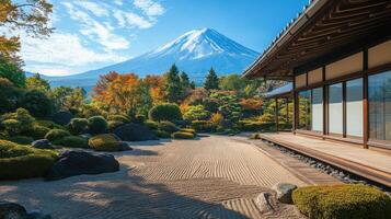 Zen garden with raked sand near traditional building and mountain in distance on a clear day with colorful autumn trees photo