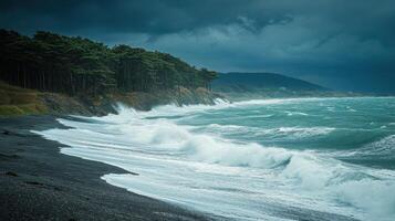 Dark pebble beach with foamy waves crashing on the shore under a stormy sky near a green forest and distant hills photo