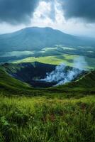 Active volcano crater emitting smoke. Green grass and small red flowers foreground. Cloudy sky over distant mountain. Natural geothermal landscape. photo
