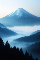Snowy mountain peak stands above blue misty valleys. Evergreen trees appear in the foreground. The scene evokes quiet and peaceful feelings. photo