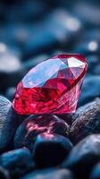 Red gem on dark pebbles. Faceted ruby or garnet stone. Sparkling jewel sitting on a pile of rocks. Focus on crystal, elegant treasure. photo