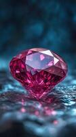 Pink gem rests on dark rock. Light shines on crystal surface. Shiny red gemstone with many facets reflects. Dark blue background with bokeh effect. photo