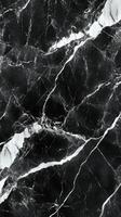 Dark surface. Black stone with white veins. Mineral texture. Detailed close up view of polished marble. Vertical abstract background photo