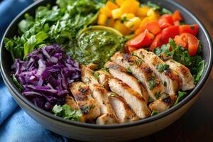 Grilled chicken salad bowl. Fresh greens with avocado dressing. Red cabbage, tomato and fruit. Balanced healthy meal close up. Delicious and nutritious food. photo