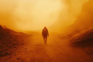 Person wearing protective suit walking on a dry planet surface during dust storm with orange sunlight. Rocky and hazy landscape background. photo