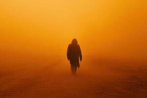 Person walks away through orange dust. Silhouette of figure in cloak on desert landscape. Mysterious hazy atmosphere. Walking into the unknown. Desert travel. photo