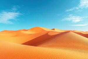 Desert landscape image. Orange sand dunes ripple under a bright blue sky with sparse white clouds. Sunlight and shadow play across the sand. photo