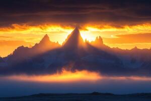 Sharp mountain peaks touch golden cloudy sky. Light rays stream through fog. Snowy rocks in background. Blue haze floats low on ground. photo