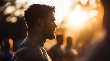 A man is standing in front of a crowd at sunset photo