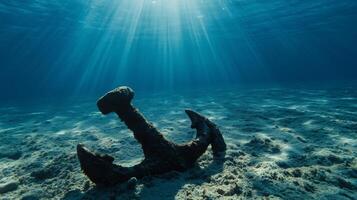Anchor underwater with sunlight on the sea floor photo