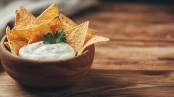 Tortilla chips with dip in a bowl on a wooden table photo