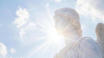 An angel statue with the sun shining through the clouds photo