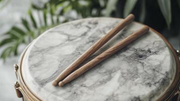 Two wooden sticks on top of a drum photo