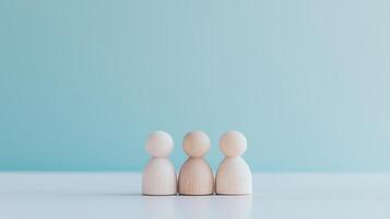 Three wooden people standing in front of a blue background photo