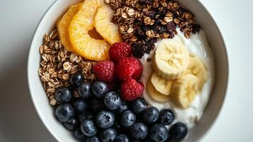 A bowl of yogurt, granola, fruit and yogurt photo