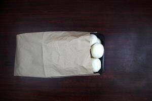 Mushrooms lie in a craft bag on a dark background photo