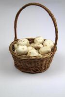Mushrooms lie in a basket on a white background photo