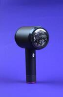 The machine against lint stands on a purple background. The concept of clothing care. photo