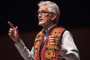 University professor gesturing while giving a lecture in university auditorium photo