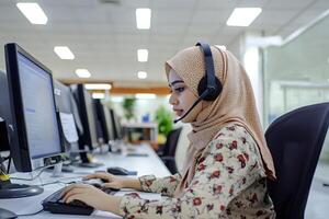 Muslim customer service representative working on computer in office photo