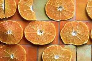 Orange slices arranged on colorful tiles creating vibrant pattern photo