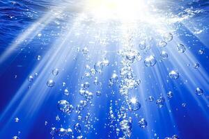 Underwater sunlight creating air bubbles rising to surface photo