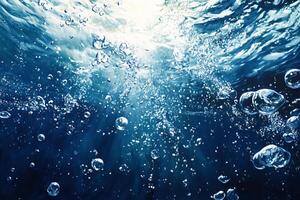 Underwater sunlight filtering through bubbles rising to surface photo