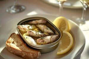 Marinated sardines in a can with lemon wedges and bread, served as appetizer photo