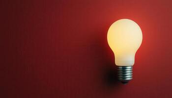Illuminated Light Bulb on Red Background with Copyspace for Creative Ideas photo