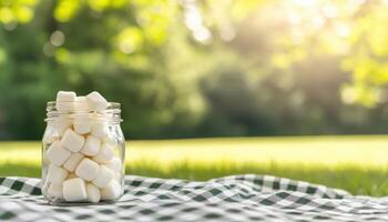 Whimsical Marshmallows in Glass Jar Outdoor Picnic Nature Background Copyspace photo