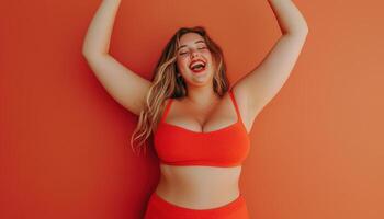 Joyful Young Chubby Woman Dancing in Bright Orange Background with Copyspace Under Sunlight photo