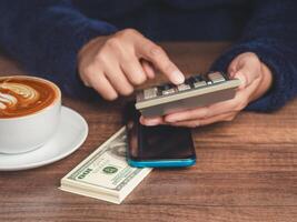 Close-up of the hand using a calculator to calculate taxes while sitting at the table photo