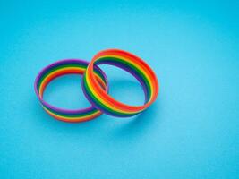 Top view of a rainbow patterned wristbands are on a blue background photo
