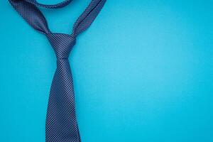 Top view of a necktie on a blue background with copy space for text photo