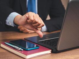 Close-up of a businessman showing a thumbs down for dislike service while sitting at the table. photo