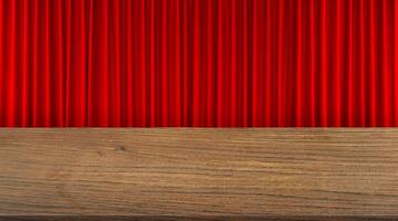 Front view of old wooden table with red curtains as background. photo
