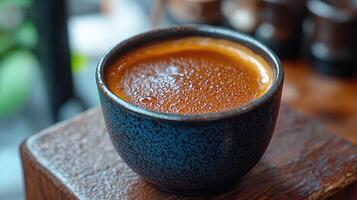 A close-up of a rich coffee in a textured cup. photo