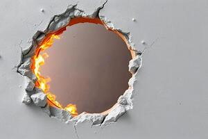 A circular hole torn through a white, cracked wall reveals flames, creating a striking contrast of destruction and fiery intensity. photo