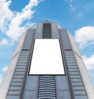 Bottom up view tower building with white mock up vertical LED display billboard. Clipping path for mock up photo