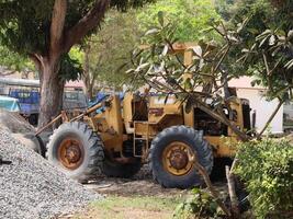 Heavy Machinery Working on a Construction Site Surrounded by Tall Green Trees and Nature photo