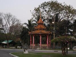 The Elegant Golden Pavilion is surrounded by lush tropical trees, creating a stunning view photo