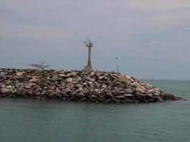 This is a fascinating Coastal Structure crowned by a beautiful Lighthouse situated on a Rocky Jetty photo