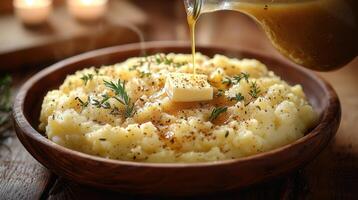 A bowl of mashed potatoes with butter and herbs photo