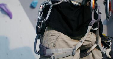 A person wearing a harness on a rock climbing wall photo
