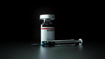 A syringe and a bottle of covid vaccine photo