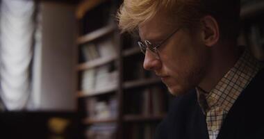 A man with glasses and a sweater photo